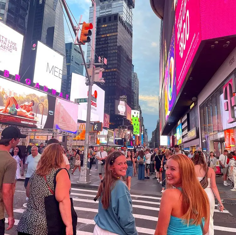 Girls look back at camera in big city.