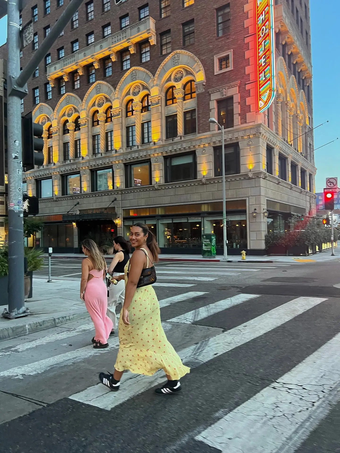 Three girls walking across a zebra crossing in evening-wear in New York.