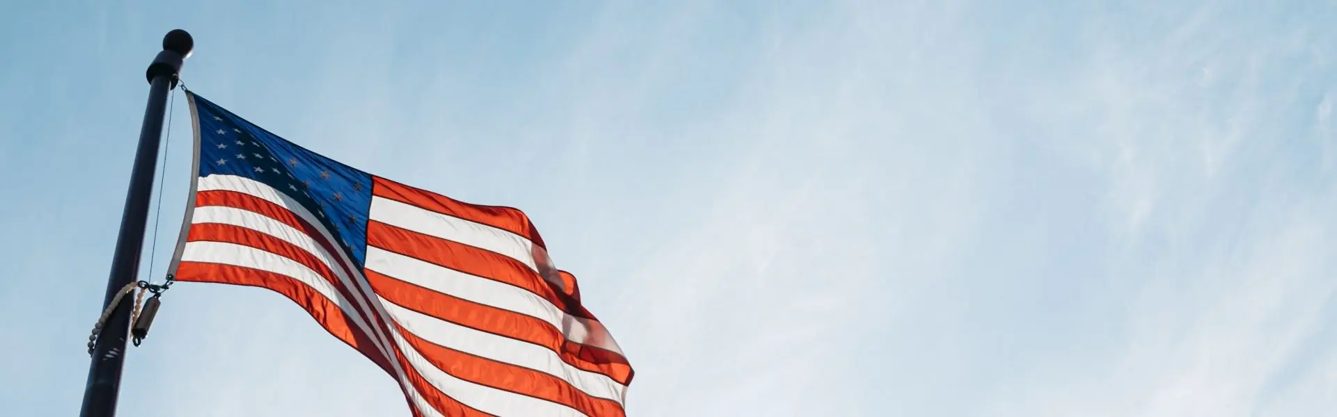 USA flag on a blue sky - Steven Abraham via Unsplash