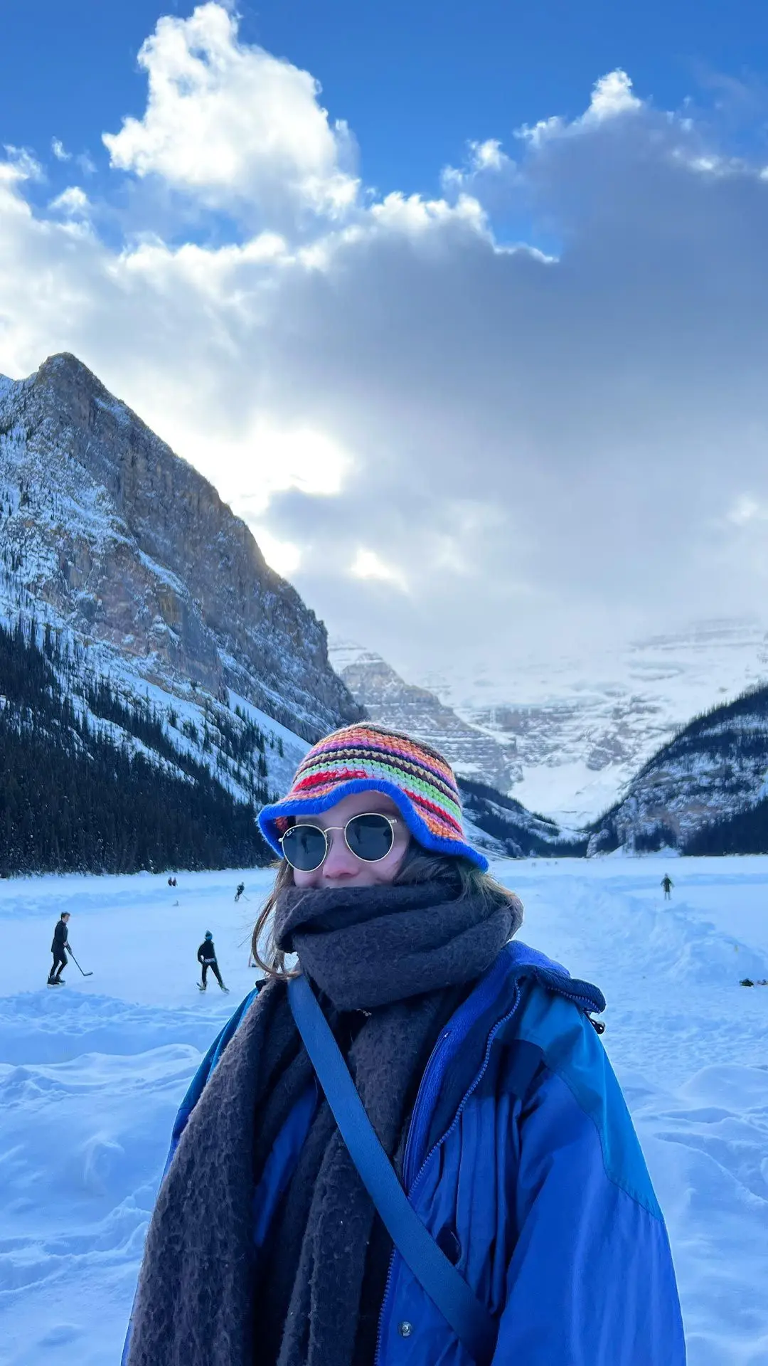 Girl posing in front of snowy mountains with sunglasses